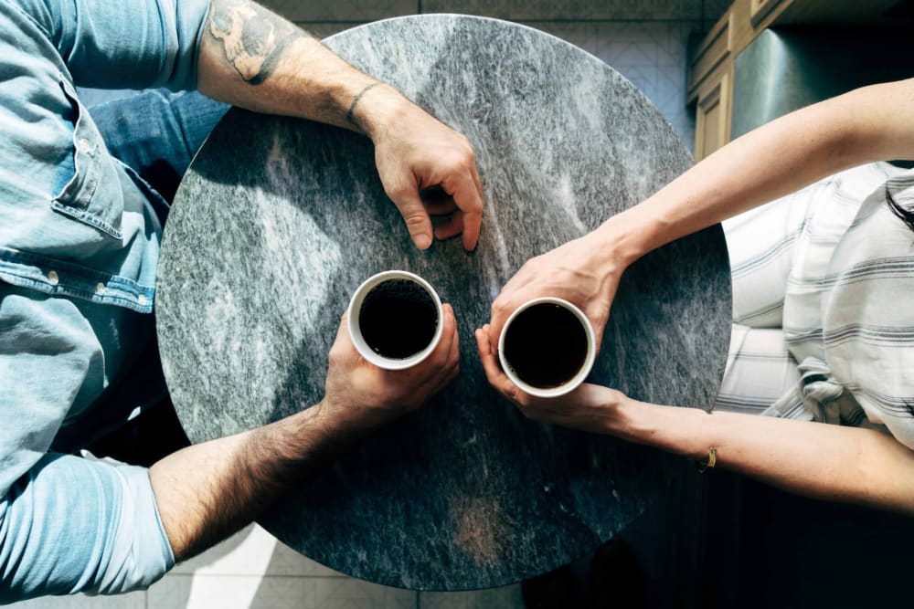 Aerial view of two people having coffee at a coffee table