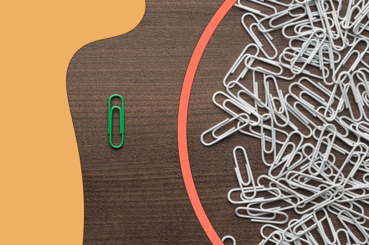 Collection of paperclips and one green single paperclip