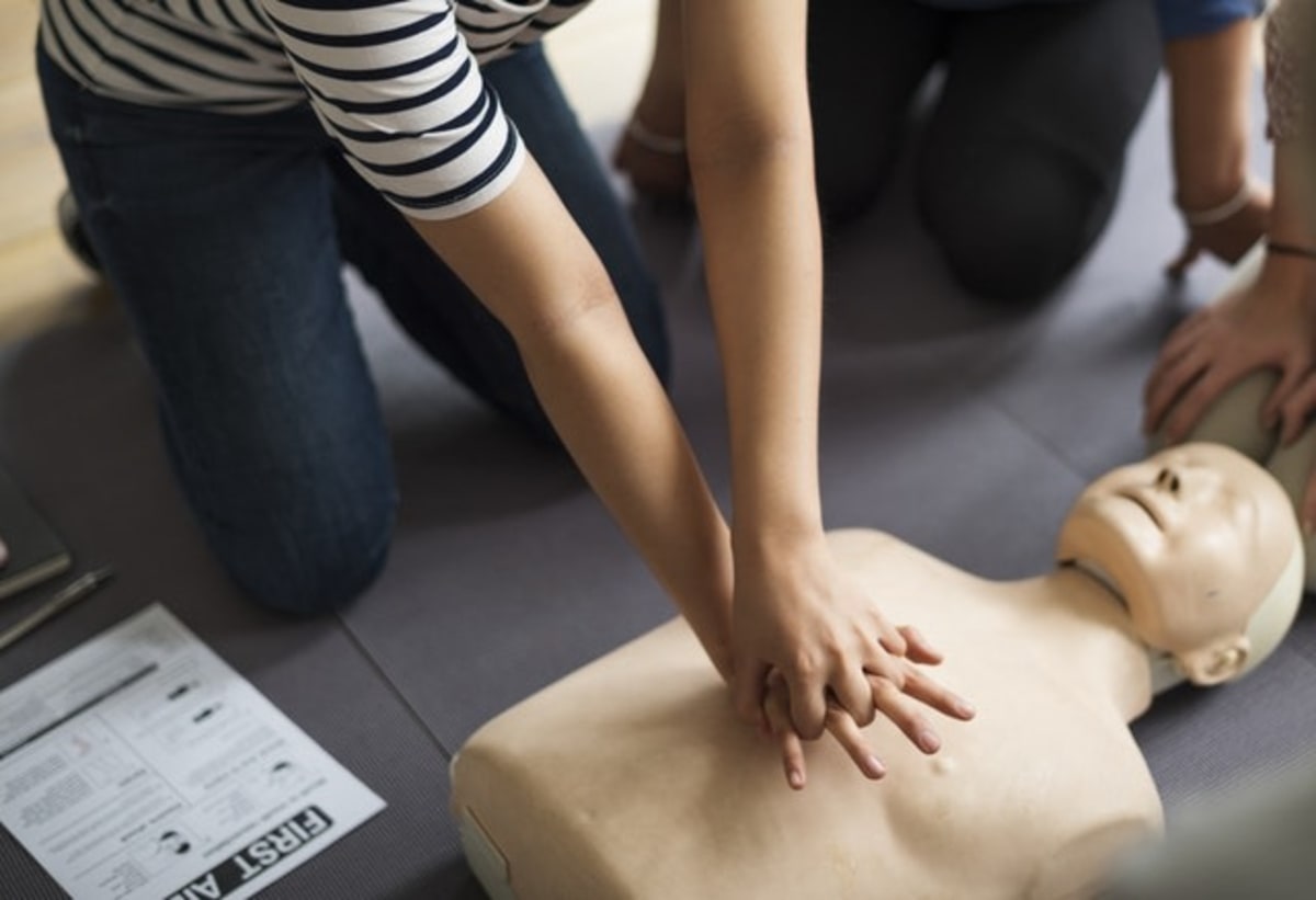 Woman performing first aid on a CPR dummy