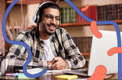 Man wearing headphones smiling at laptop