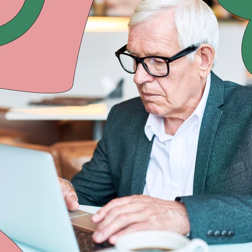Older man with glasses sitting down in front of a laptop