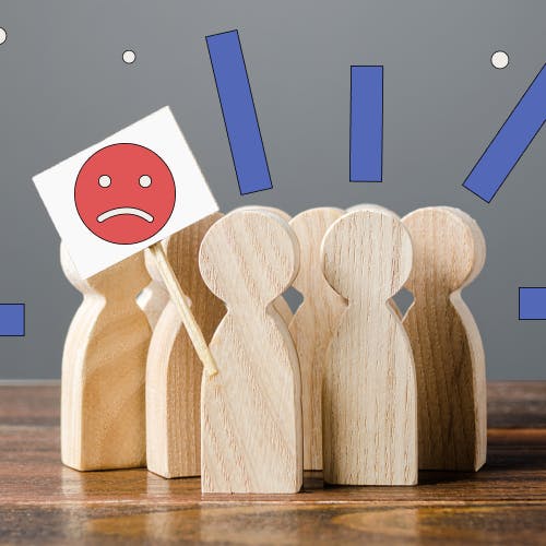 Grouping of wooden peg figurines with sad face graphic