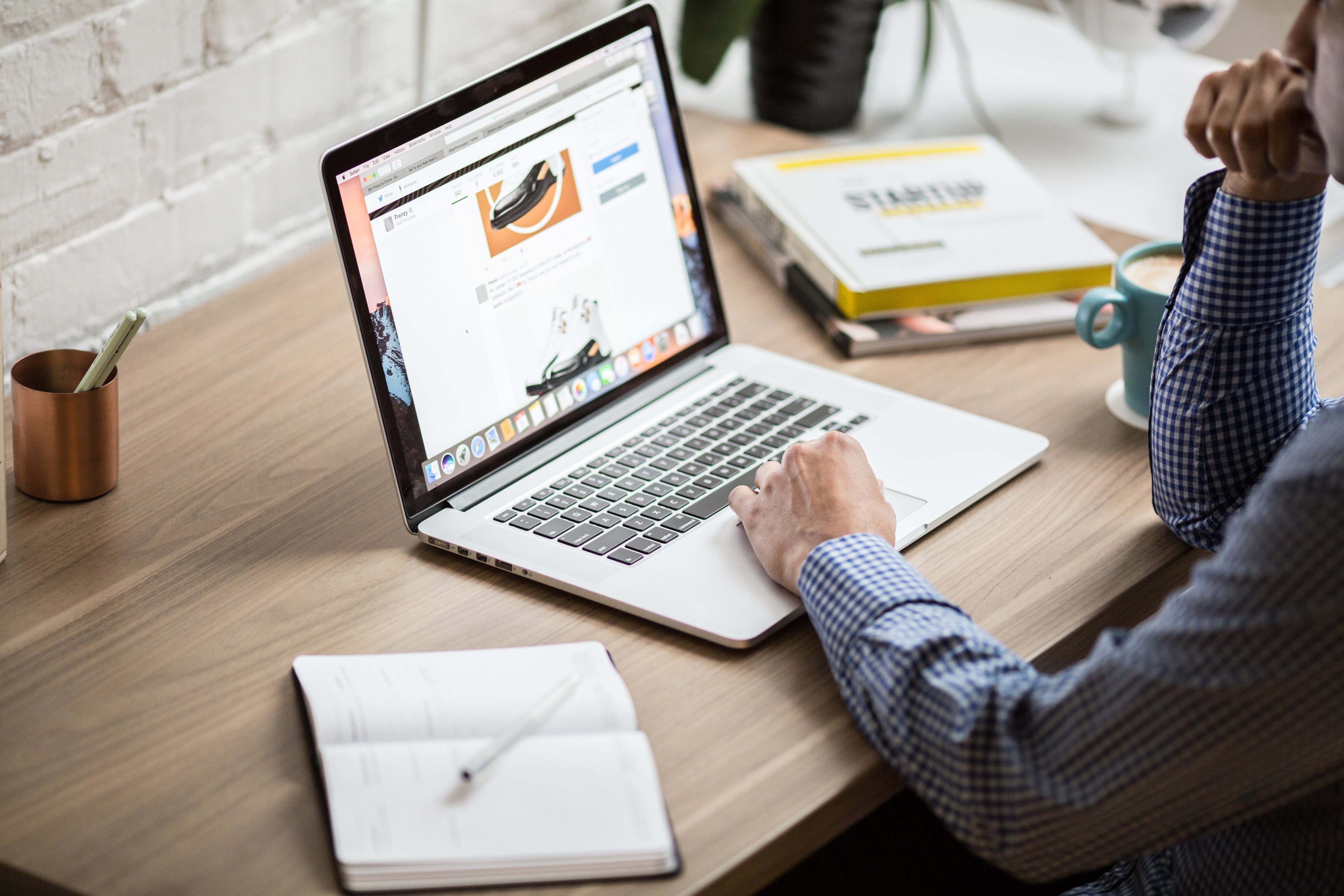 Man sitting at a home office typing on a laptop