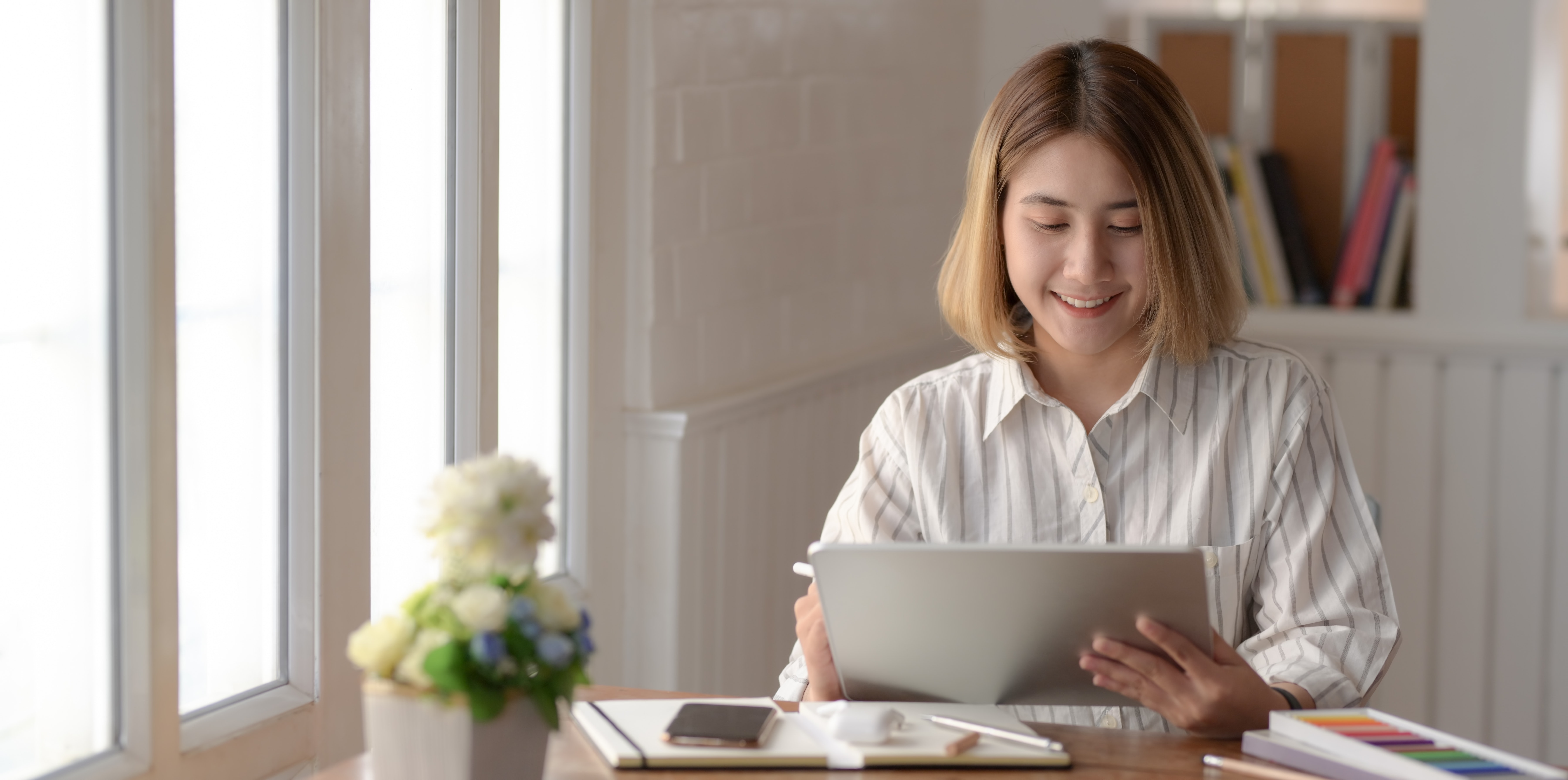 Woman at home smiling at her notebook