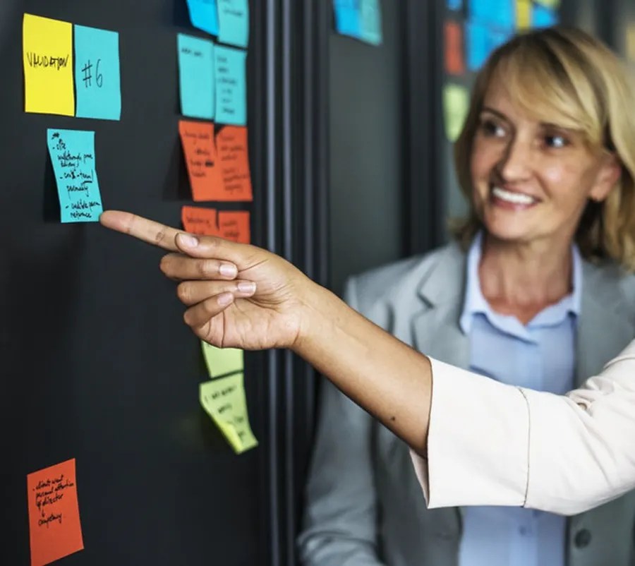 Two women in an office prioritising different tasks on sticky notes