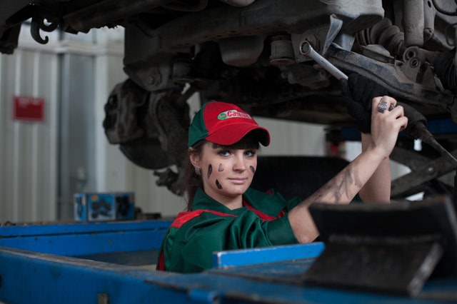Woman working on a car, representing training in the automotive industry