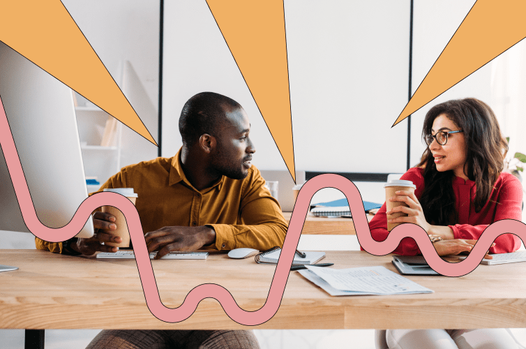 Two people sitting at a table working and talking